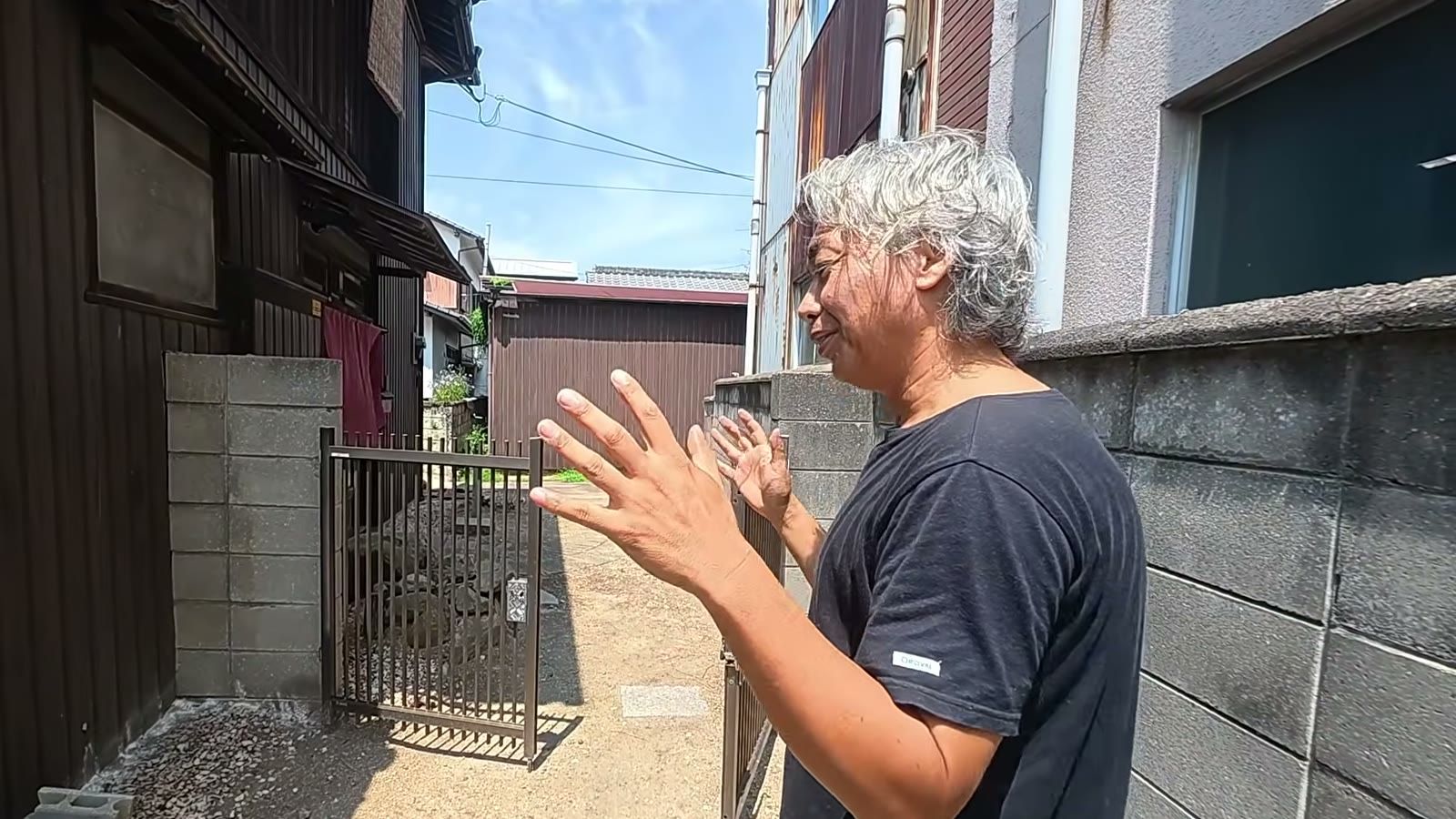 古民家の前で、手ぶりを交えて柵の話をする宮前