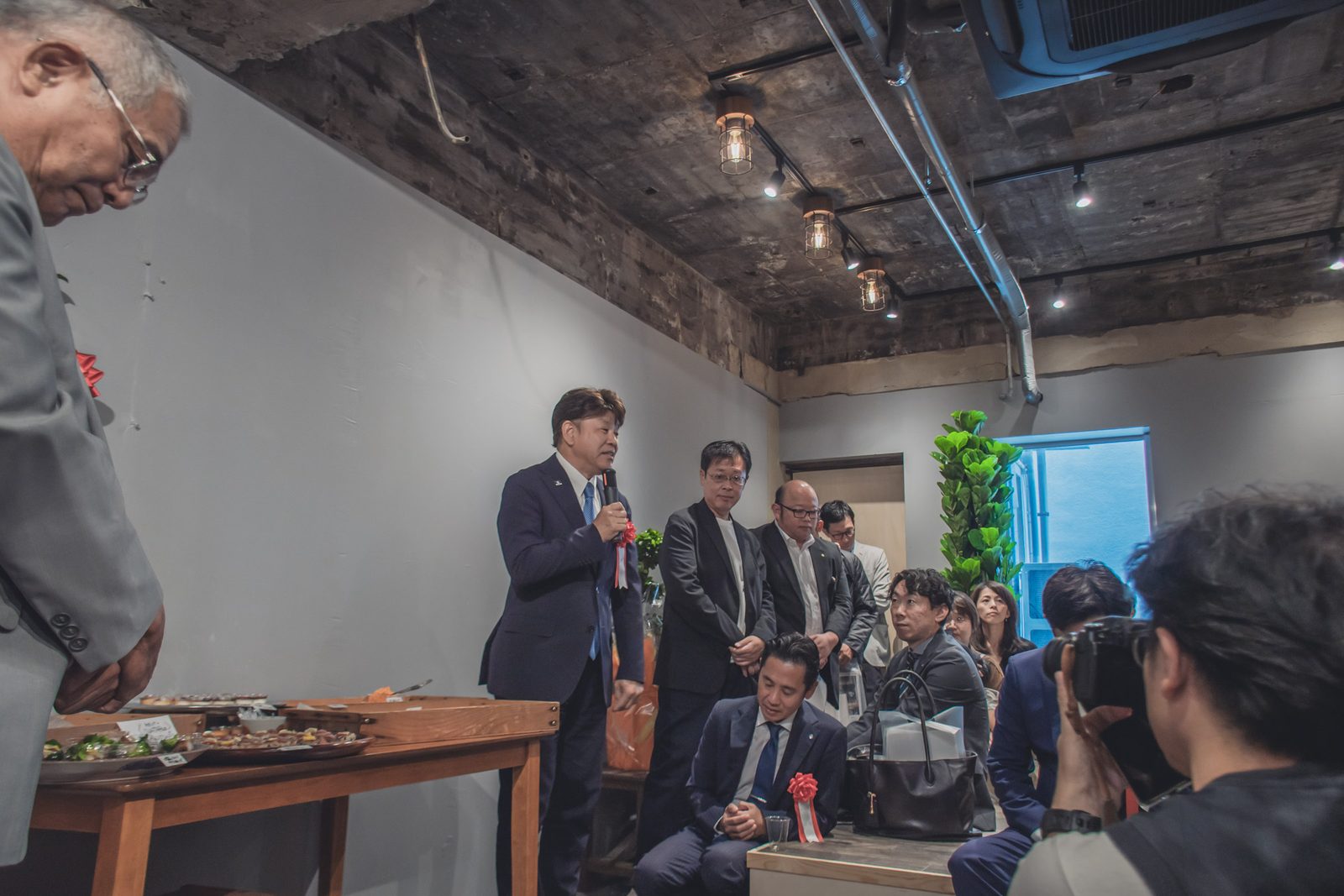 会場でのあいさつに集まった人たち